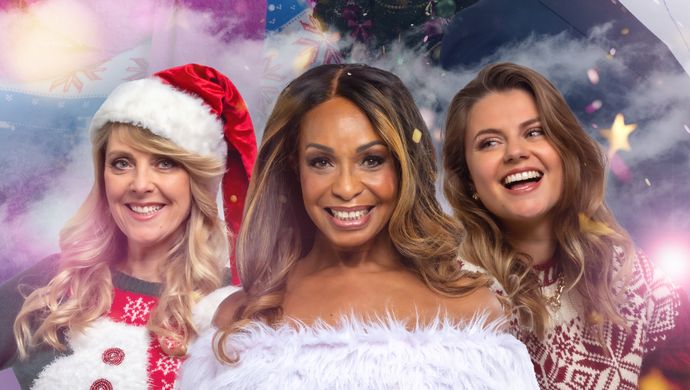 foto van vier vrouwen en een man in kerstkleding met een kerstboom.