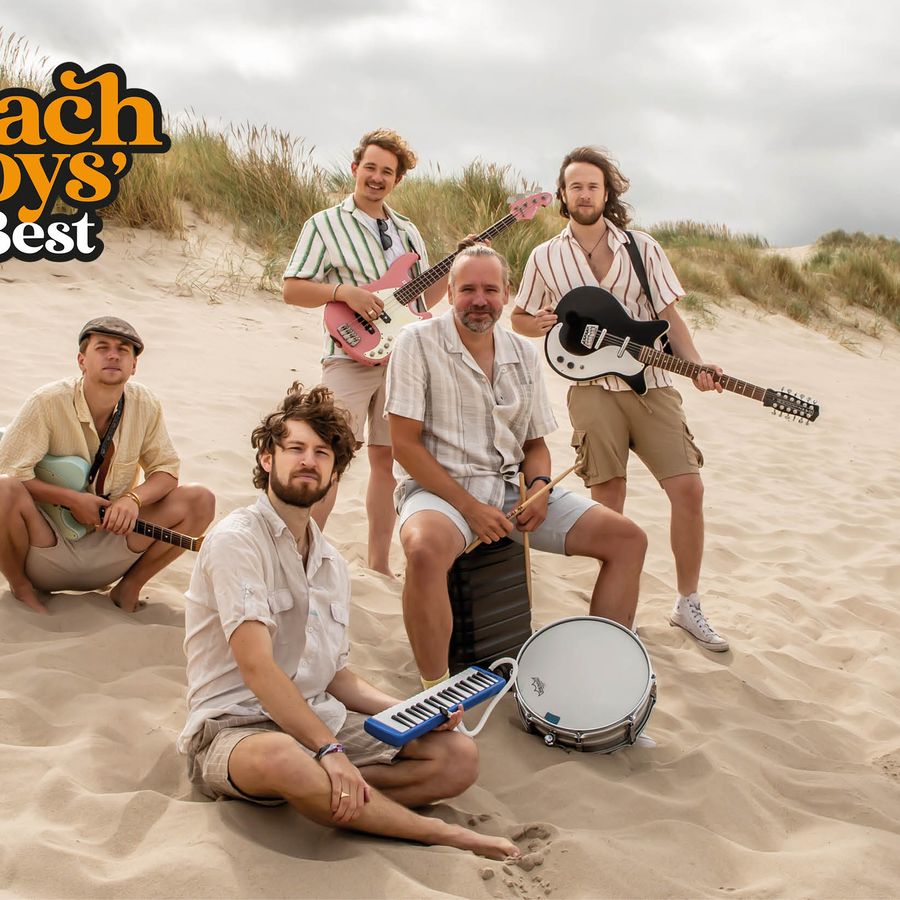 Een foto van vijf jonge mannen op het strand.