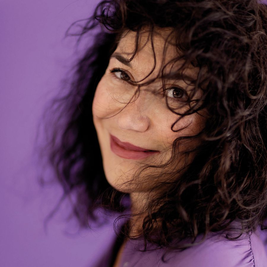 Nilgün Yerli in het paars gekleed met een paarse achtergrond.