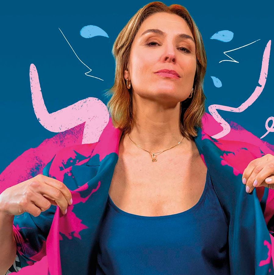 Evi met een fel roze jas aan op een blauwe achtergrond.