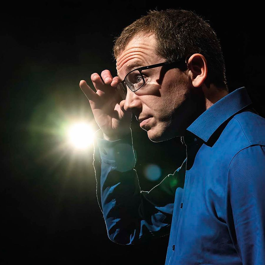 Chris houd zijn bril vast en kijkt naar de zijkant.