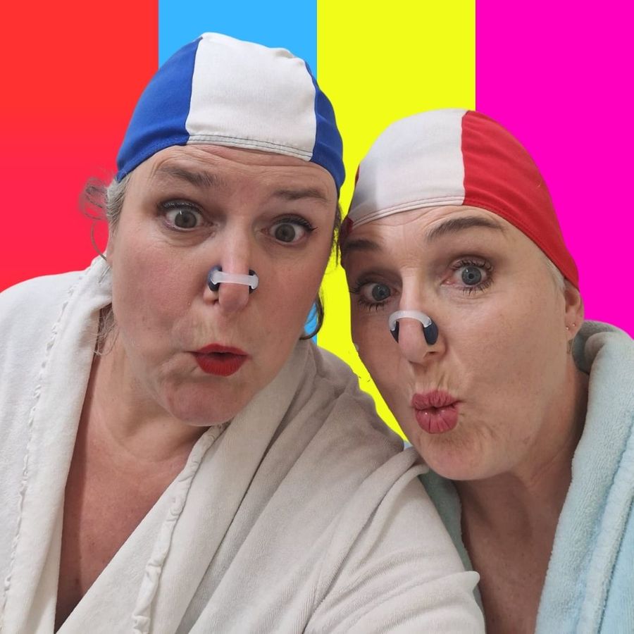 Wendie en Renate met badmutsen op met een kleurrijke achtergrond.