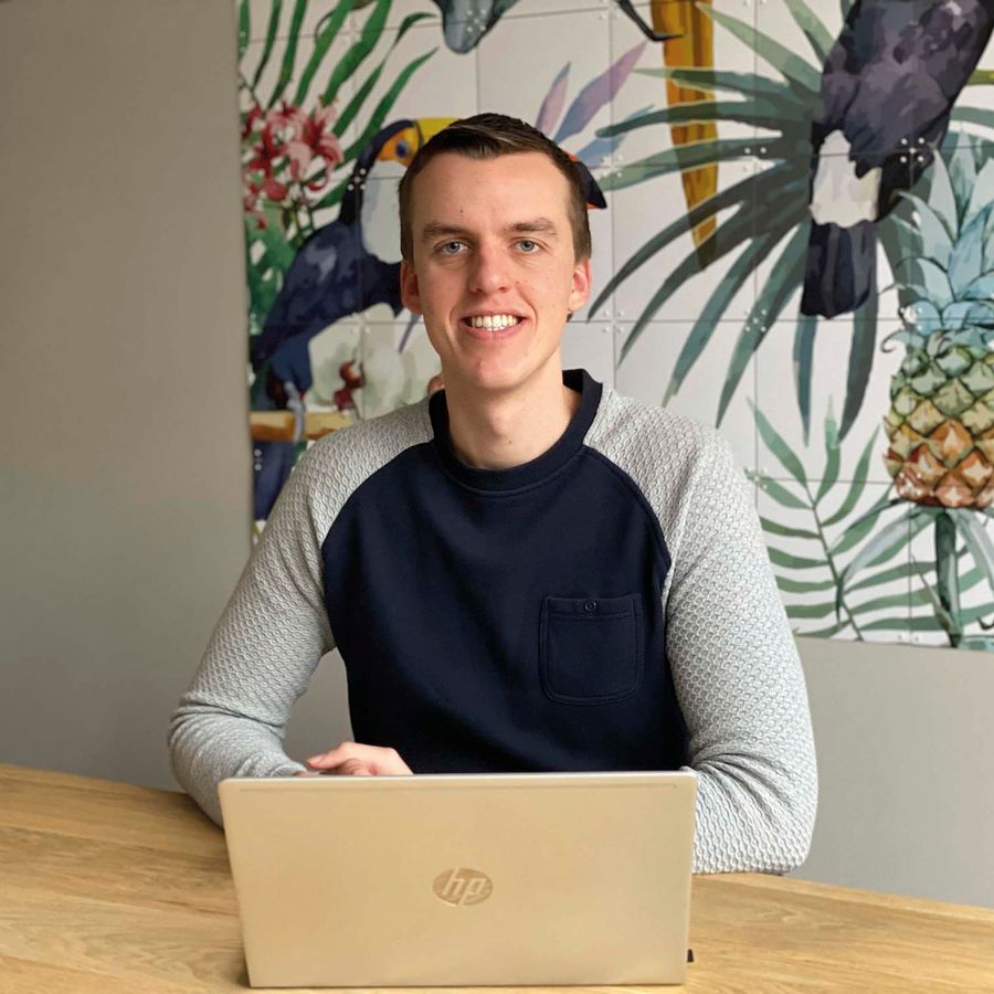 Menno zit aan tafel voor zijn laptop.