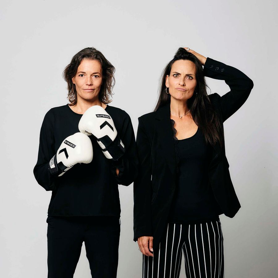 Ilse en Marieke naast elkaar. De een heeft bokshandschoenen aan en de ander trekt een gek gezicht.